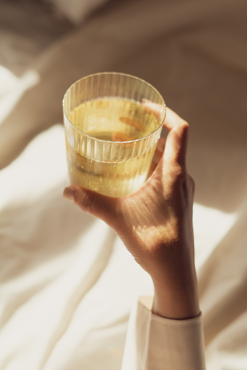 Person's Hand Holding a Glass of Tea